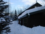 Snow curling off our garage with icicles